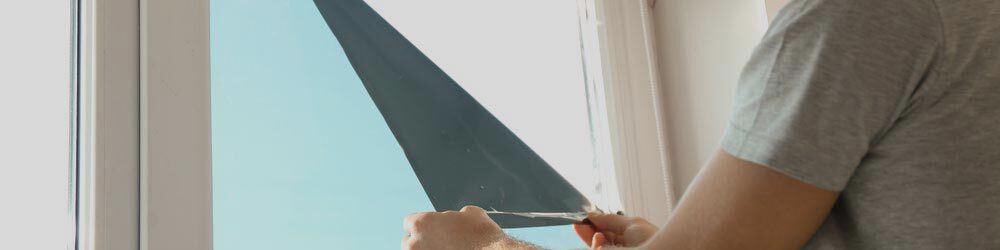 Man Tinting A Window With A Film