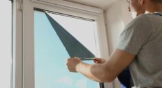 Man Tinting A Window With A Film