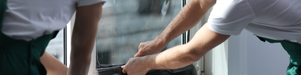 Men Installing Security Window Film in Commercial Area